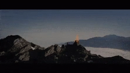 A Mountain Covered In Snow With A Few Clouds In The Sky GIF