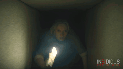 A Movie Poster For Insidious Shows A Woman Holding A Flashlight In A Dark Room GIF
