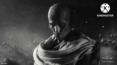A Movie Poster For Thor Ragnarok Shows A Bald Man With A Scarf Around His Neck GIF