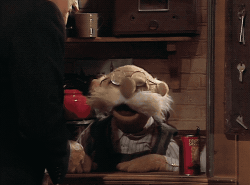 A Muppet Is Sitting At A Table With A Can Of Popeye 'S GIF