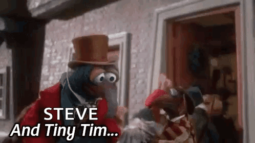 a muppet wearing a top hat is standing in front of a building .