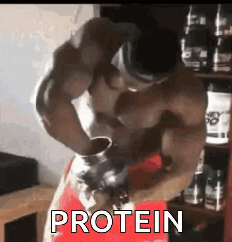 A Muscular Man Is Drinking Protein From A Bottle . GIF