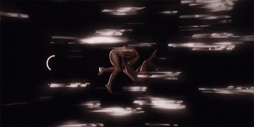 A Naked Man Is Being Held Up By Another Man In A Dark Room GIF