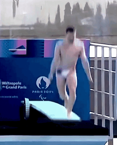 A Naked Man Is Jumping Into A Pool With A Sign That Says Metropole Grand Paris On It GIF