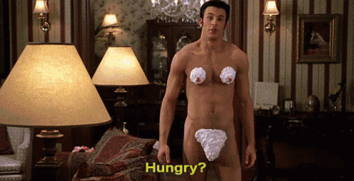 A Naked Man With Whipped Cream On His Chest Is Standing In A Living Room Asking If He Is Hungry GIF