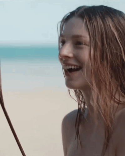A Naked Woman Is Laughing On The Beach GIF