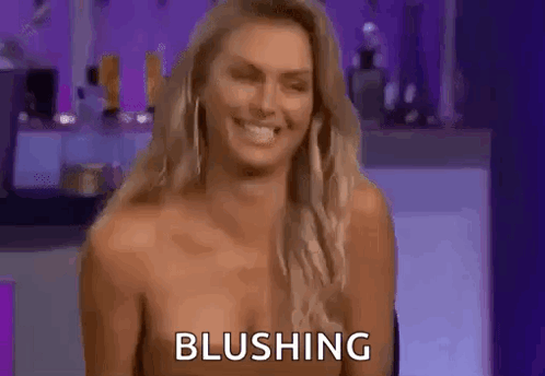 A Naked Woman Is Smiling And Blushing While Sitting On A Chair . GIF