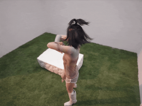 A Naked Woman Is Standing In A Room With A White Box GIF