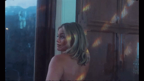 A Naked Woman Is Standing In Front Of A Window GIF