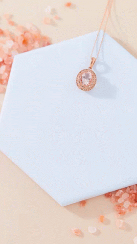 A Necklace Is Sitting On A Blue Tile Next To A Pile Of Salt GIF