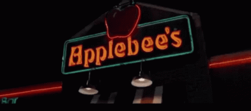 A Neon Sign For Apple 'S Bar Is Lit Up In The Dark GIF