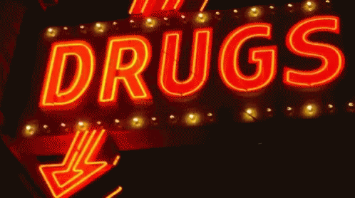 a neon sign for drugs with an arrow pointing to the right
