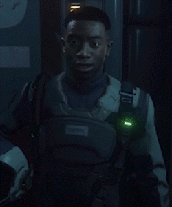 A Neon Sign That Says Wish Him Luck With A Man Behind It GIF