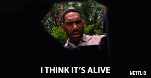 A Netflix Ad Shows A Man Looking Through A Hole In A Wall And Says I Think It 'S Alive GIF