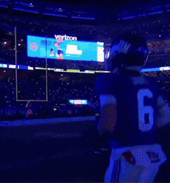A New York Giants Football Player Stands In Front Of The Metlife Stadium GIF