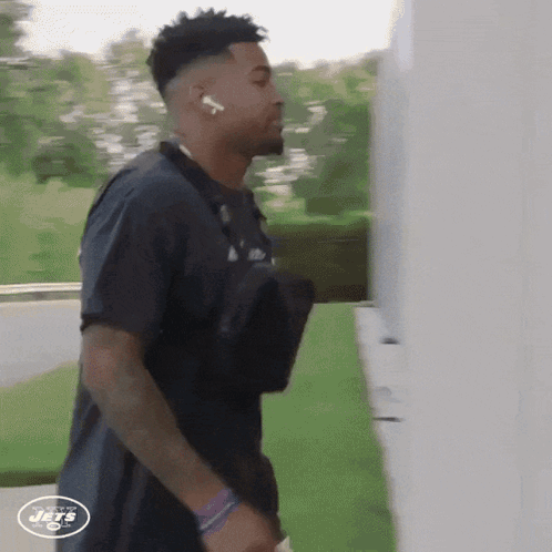 A New York Jets Player Is Walking Down A Street GIF