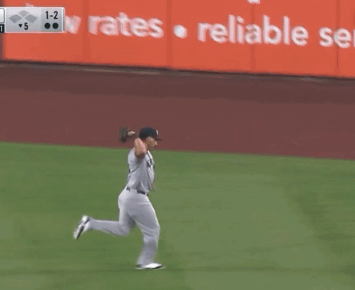 A New York Yankees Baseball Player Is Running Towards A Base GIF