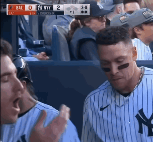 a new york yankees baseball player is sitting in the dugout
