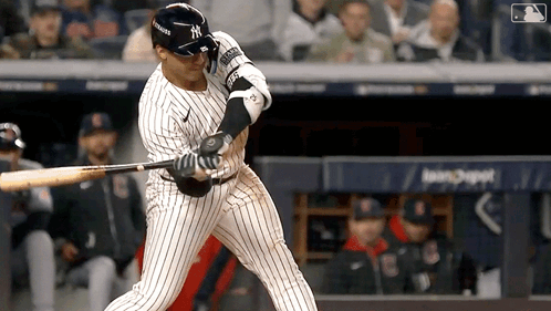 A New York Yankees Baseball Player Swings His Bat At The Ball GIF
