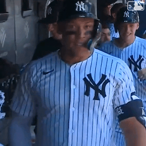 A New York Yankees Baseball Player Wearing A Helmet And A Striped Shirt GIF