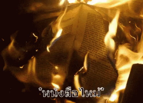 A Newspaper Is Burning In A Dark Room With The Words " หนังสือ ใหม่ " Written On The Bottom GIF
