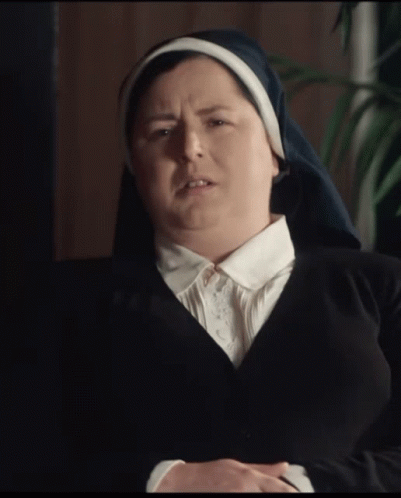 A Nun Wearing A Black Jacket And A White Collar Is Making A Funny Face GIF