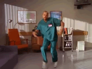 A Nurse In Scrubs Is Dancing In A Room GIF
