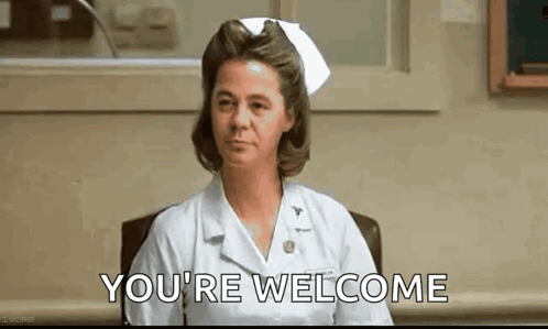 A Nurse Is Sitting At A Desk In A Hospital Room And Saying `` You 'Re Welcome '' . GIF