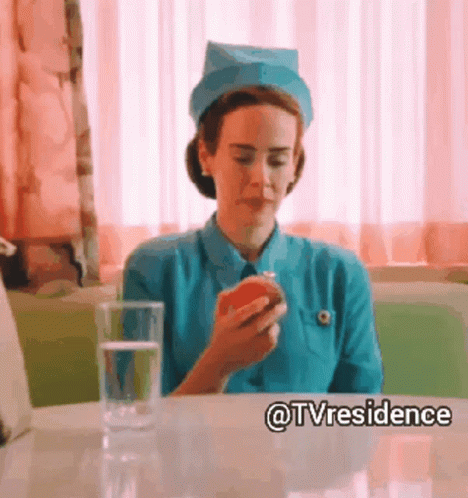 A Nurse Is Sitting At A Table With An Apple And A Glass Of Water GIF