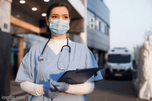 A Nurse Wearing A Mask And Gloves Holds A Clipboard GIF