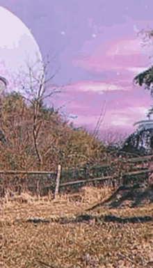 A Painting Of A Field With A Fence And Trees In The Background . GIF