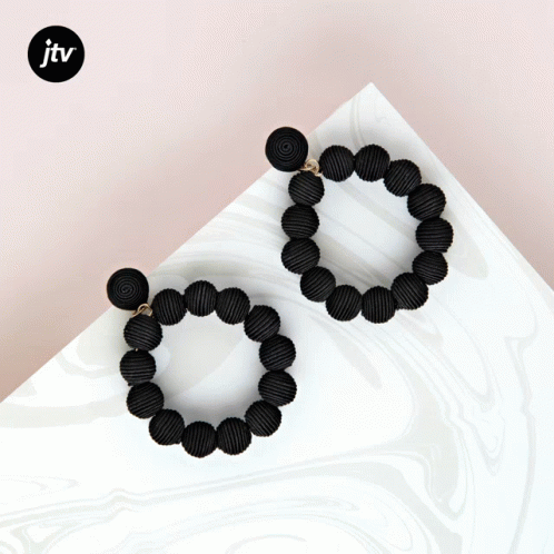 A Pair Of Black Beaded Hoop Earrings With A Jtv Logo GIF