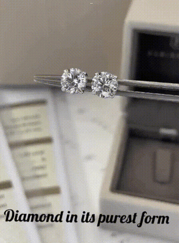 A Pair Of Diamond Stud Earrings Being Held In Tweezers With The Words " Diamond In Its Purest Form " Below Them GIF