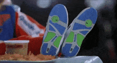 A Pair Of Flip Flops Are Laying On A Table Next To A Bag Of French Fries GIF