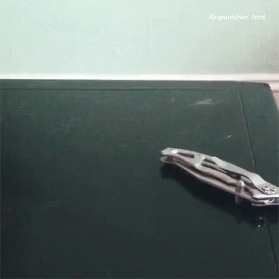 a pair of pliers laying on a black surface with a caption that says ig punisher_izrd