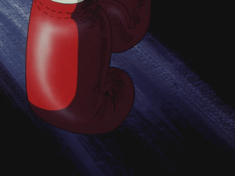 A Pair Of Red Boxing Gloves Are Hanging From A Wall GIF
