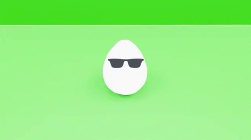 a pair of white eggs with black spots on them on a green surface
