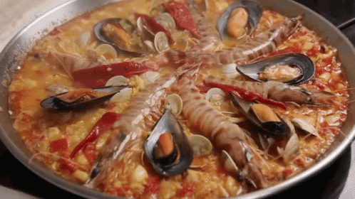 A Pan Filled With A Variety Of Seafood Including Shrimp Mussels And Peppers GIF