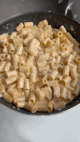 A Pan Filled With Macaroni And Cheese Being Cooked GIF