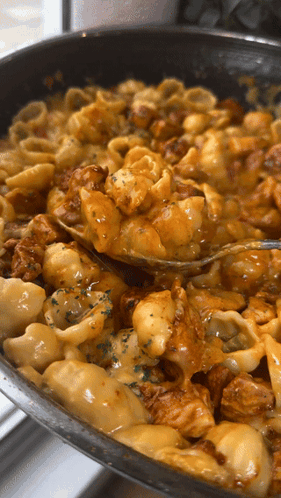 A Pan Of Macaroni And Cheese With A Fork In It GIF