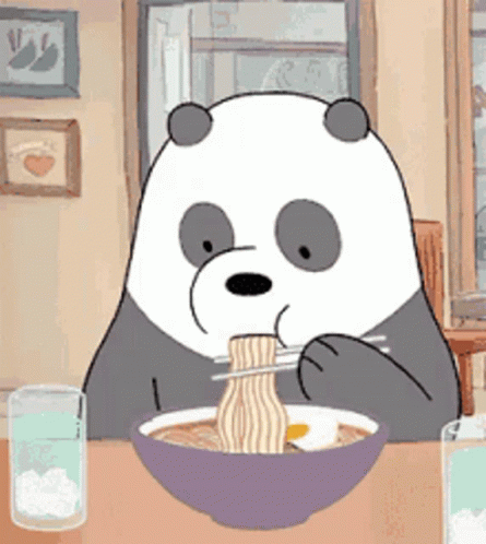 a panda bear is sitting at a table eating ramen with chopsticks .