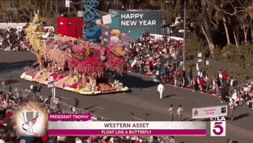 A Parade With A Float That Says President Trophy On It GIF