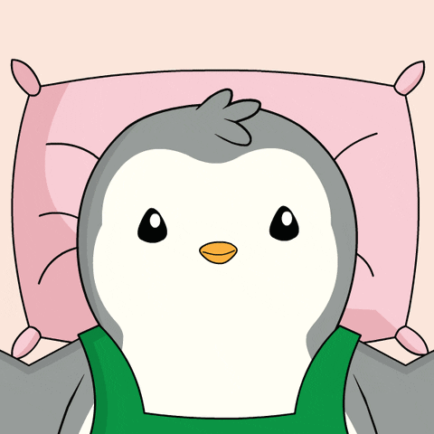 A Penguin Is Laying On A Pink Pillow With A Green Shirt On GIF
