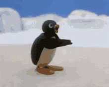 A Penguin Is Standing On Its Hind Legs On A Snowy Beach . GIF
