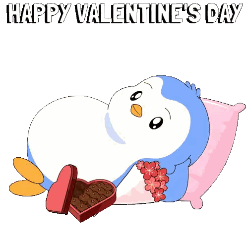 a penguin laying on a pillow with a box of chocolates