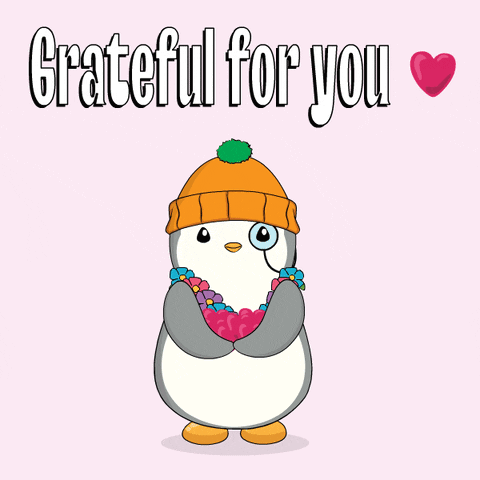 A Penguin Wearing A Beanie And Flowers Around Its Neck Is Grateful For You GIF