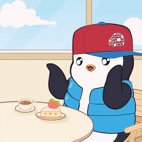 A Penguin Wearing An Igloo Hat Sits At A Table GIF