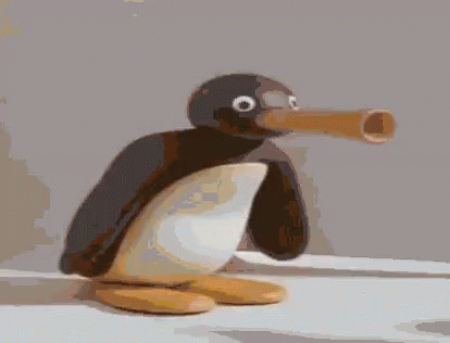 A Penguin With A Large Beak Is Sitting On A White Surface GIF