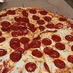A Pepperoni Pizza Is Sitting In A Cardboard Box With A Slice Missing . GIF