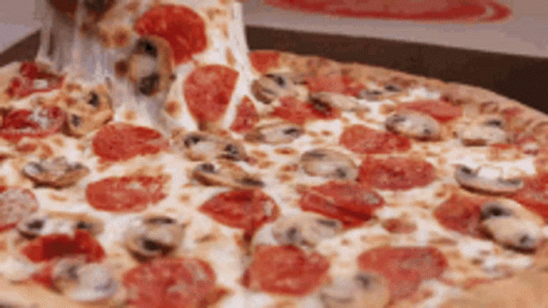 A Pepperoni Pizza With Mushrooms And Cheese Being Taken Out Of A Box GIF